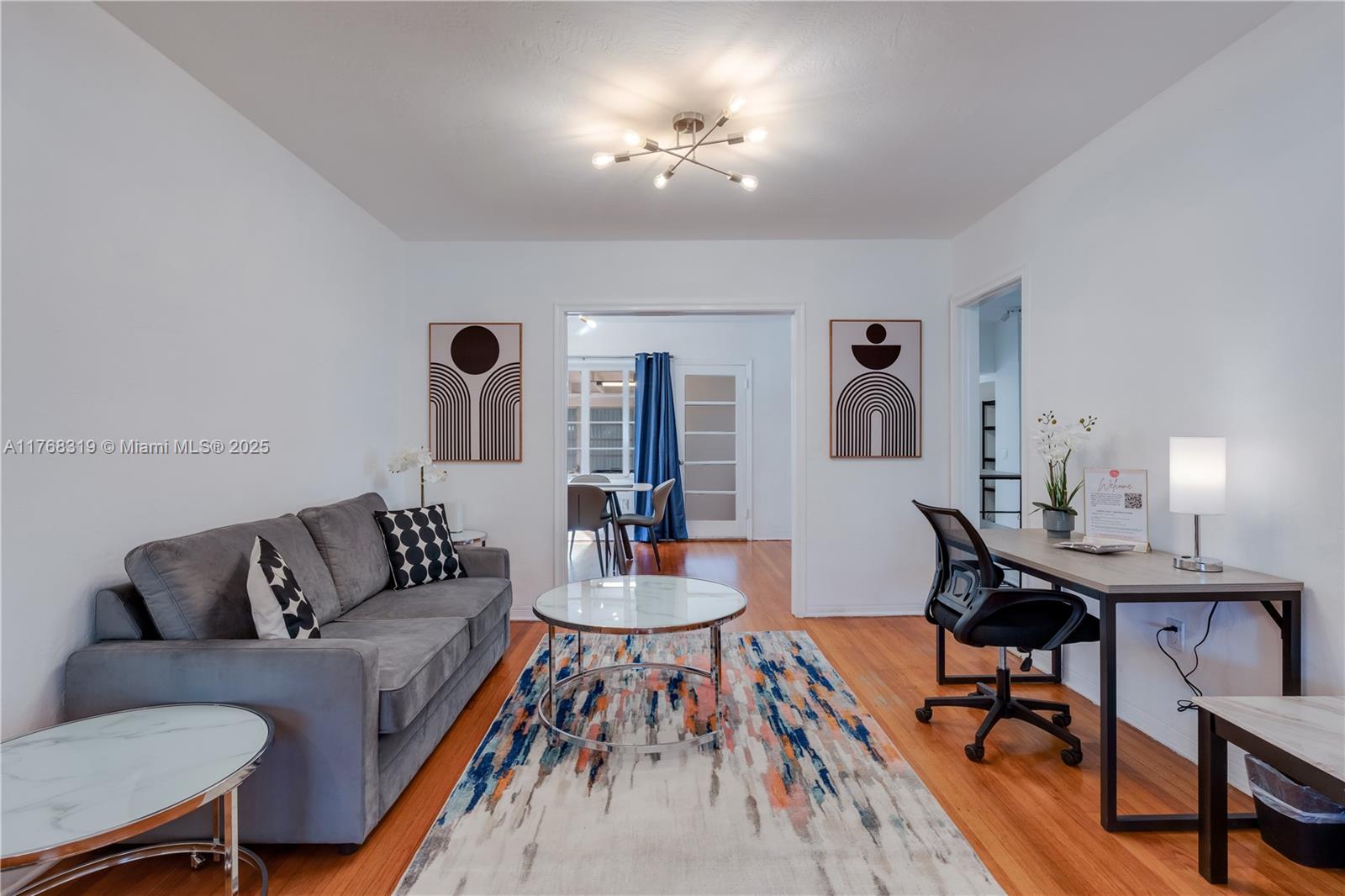 820 Southwest 26th Road Miami, FL 33129 - Photo 6 of 25 a living room with furniture and a chandelier