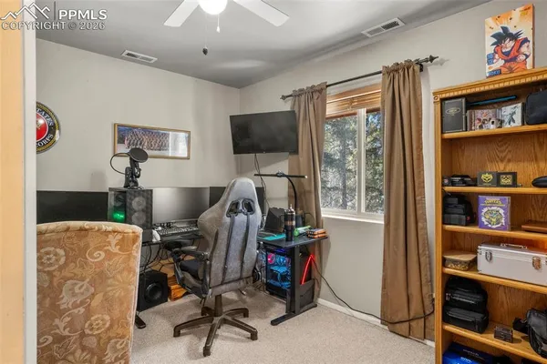 a view of a workspace with furniture and a window