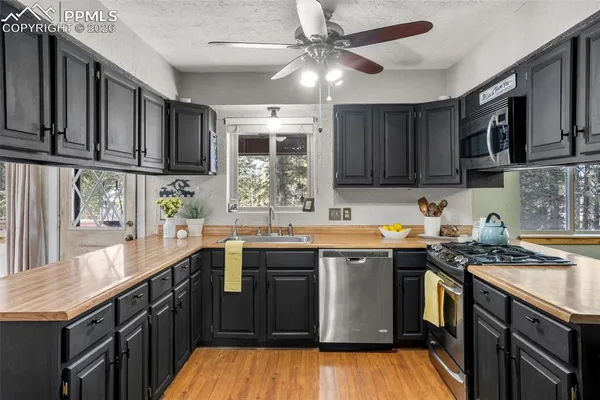 a kitchen with stainless steel appliances granite countertop a sink stove and cabinets