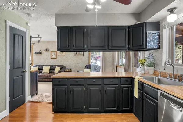 a kitchen with granite countertop a sink cabinets and stainless steel appliances