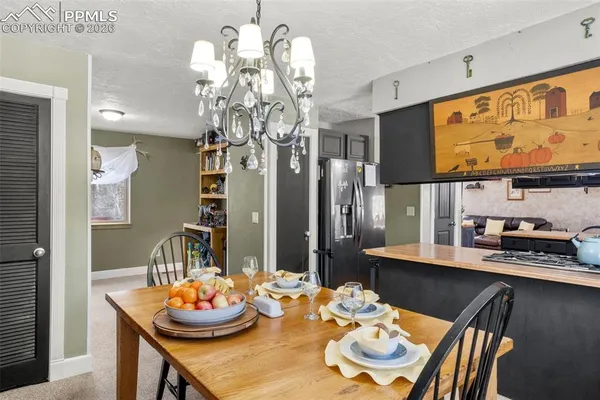 a view of a dining room with furniture a chandelier and wooden floor