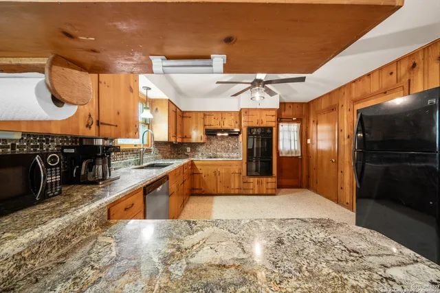 a kitchen with stainless steel appliances kitchen island granite countertop a refrigerator and stove
