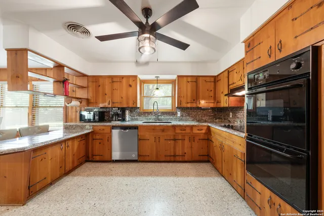 a large kitchen with stainless steel appliances granite countertop a refrigerator and a sink