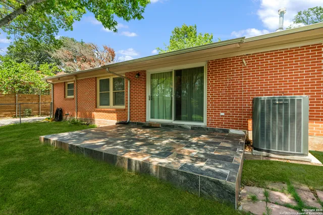a view of a backyard with table and chairs and a large tree