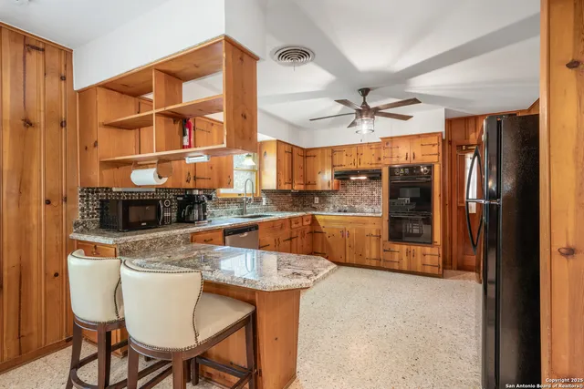a kitchen with stainless steel appliances granite countertop a sink a stove and a refrigerator