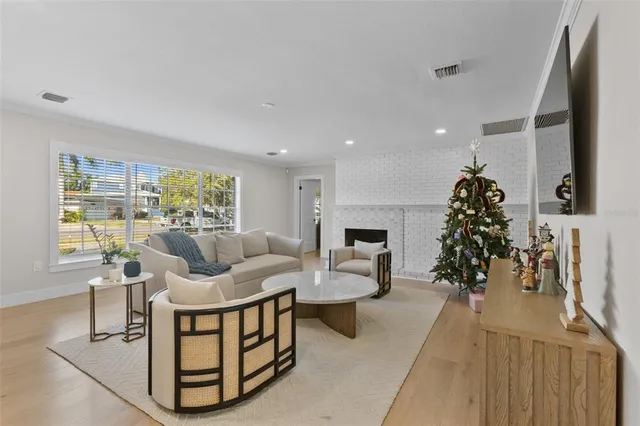 a view of a livingroom with furniture a ceiling fan and wooden floor