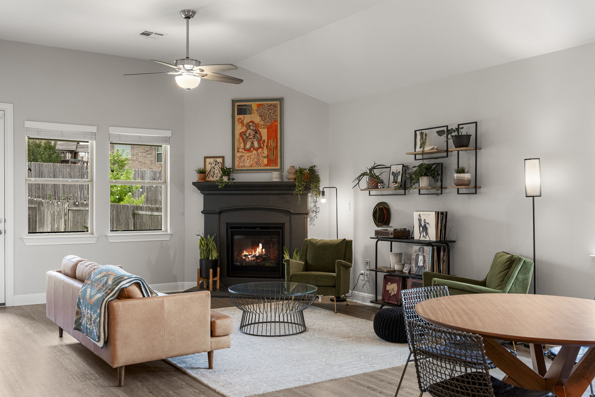 772 Founders Ridge Dripping Springs, TX 78620 - Photo 3 of 40 The open-concept living room is anchored by a gas fireplace and framed by natural light, offering a comfortable space for both everyday living and entertaining.