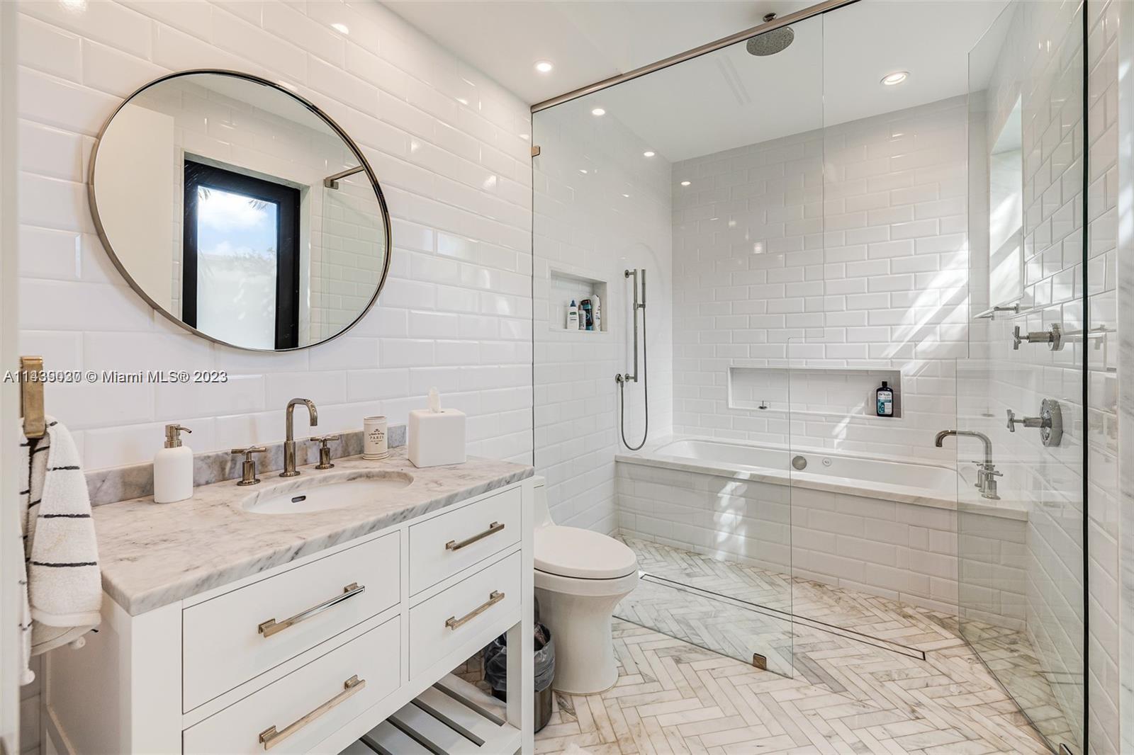 23 Samana Drive Miami, FL 33133 - Photo 12 of 19 a spacious bathroom with a granite countertop sink a toilet a mirror and shower