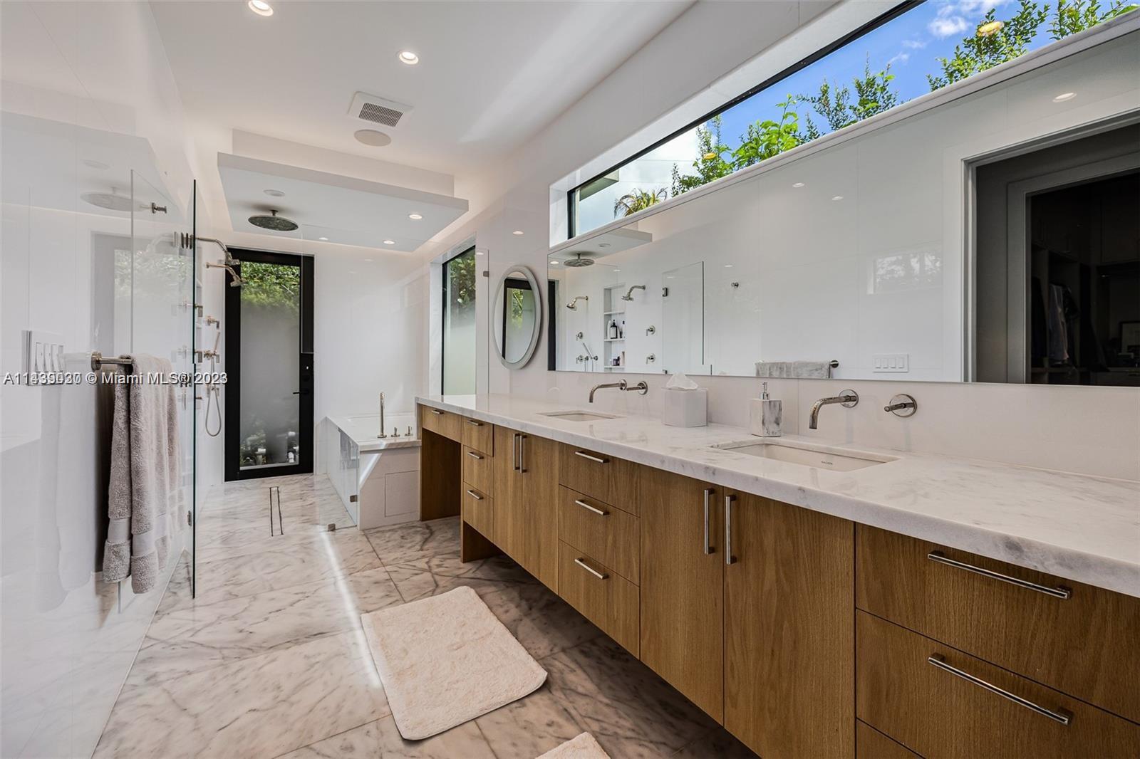 23 Samana Drive Miami, FL 33133 - Photo 10 of 19 a spacious bathroom with a double vanity sink and a mirror