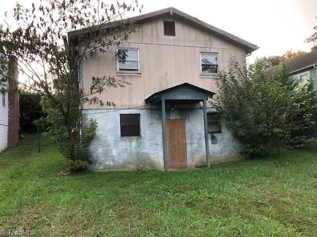 1114 Tipton Street High Point, NC 27262 - Photo 2 of 10 Rear View: Here we can see the covered rear entrance door to the basement, the green grass, mature trees and landscaping.