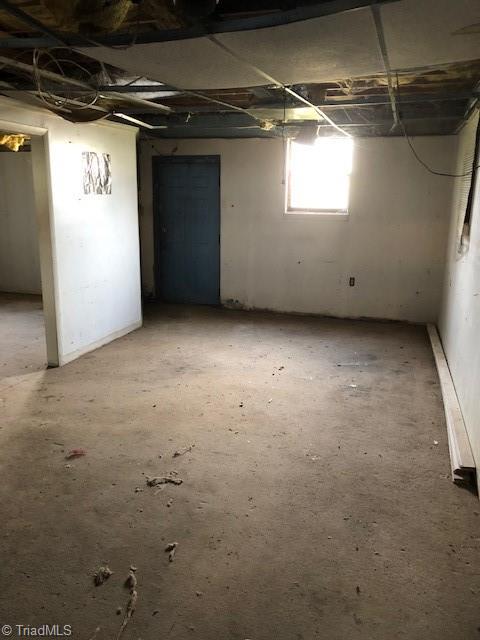 1114 Tipton Street High Point, NC 27262 - Photo 10 of 10 Basement Room 2: Here we can see room two. At the far end is a entry door from the backyard and a window for natural lighting. The opening to the left side is to room one.