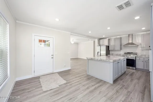 a kitchen with granite countertop white cabinets and stainless steel appliances