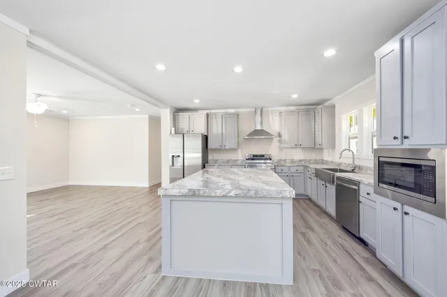 a kitchen with stainless steel appliances granite countertop a stove a sink and a refrigerator