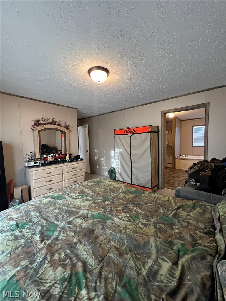 53720 Highway 681 Reedsville, OH 45772 - Photo 10 of 25 Interior room with textured walls and ceiling, featuring a cream-colored dresser with six drawers and dark pull handles