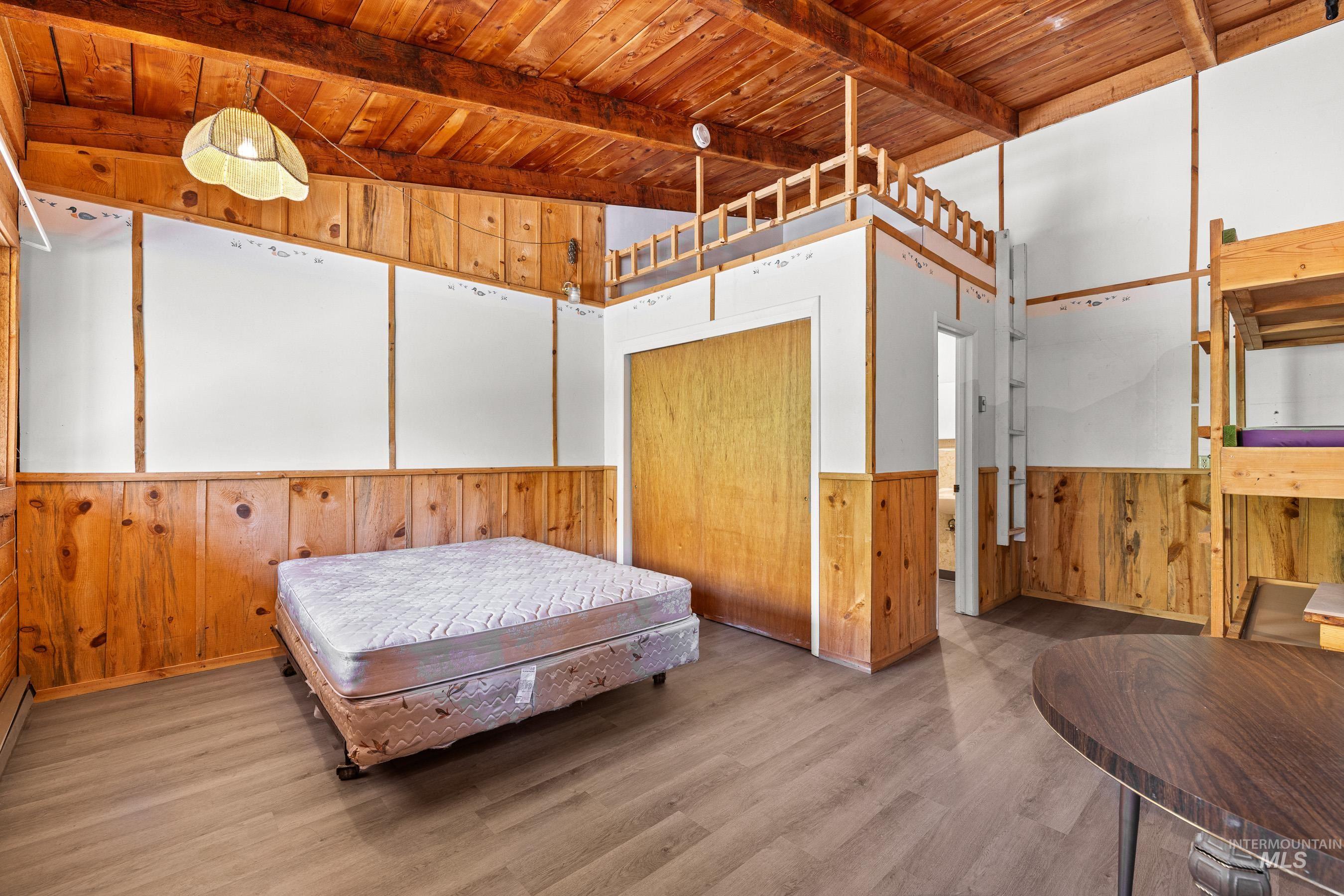 192 East Shingle Creek Road Riggins, ID 83549 - Photo 43 of 50 Bedroom with wooden walls, a wood ceiling with exposed beams, wood finished floors, and wainscoting