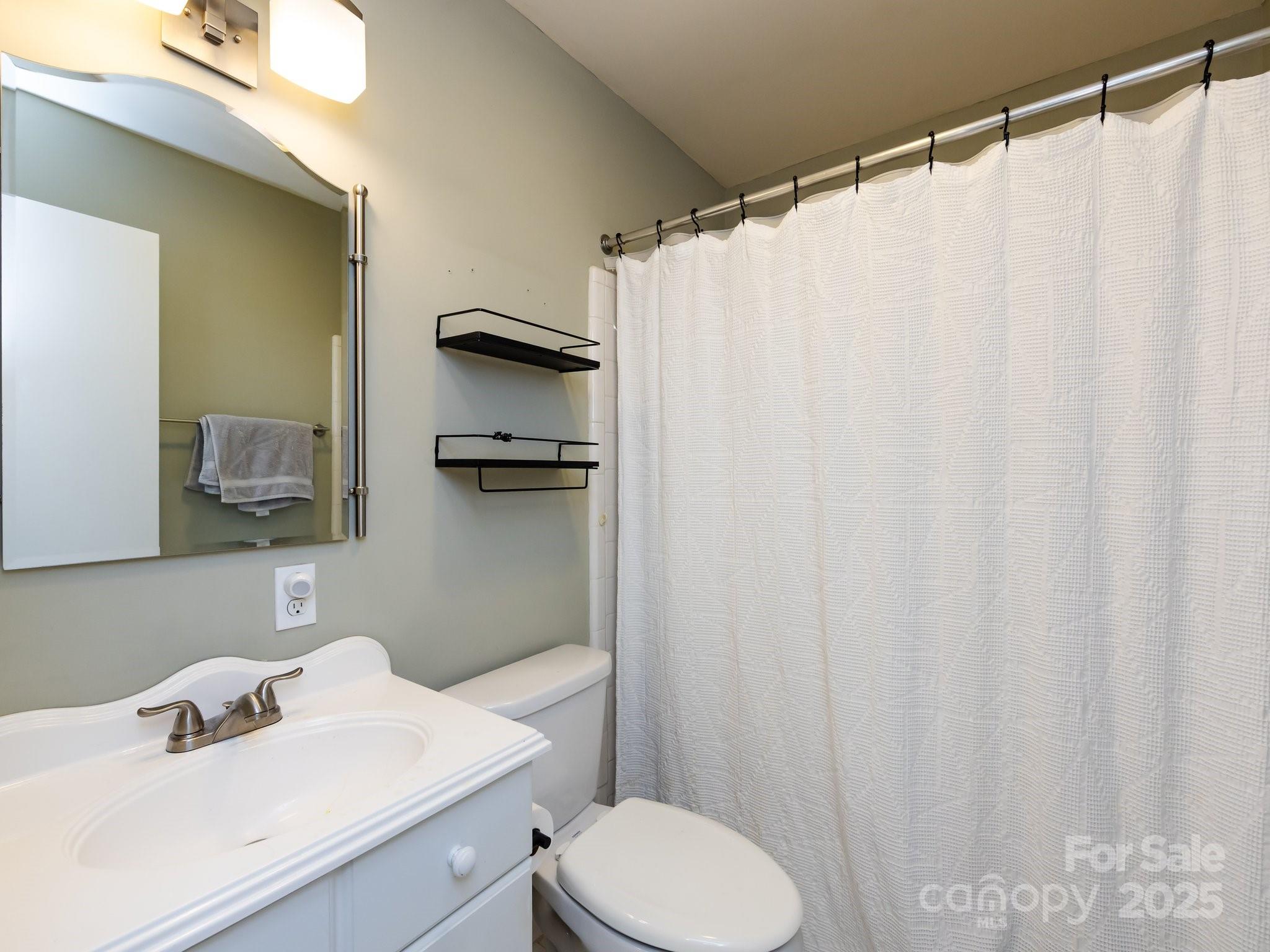 5809 Sharon Road, Unit G Charlotte, NC 28210 - Photo 17 of 25 a bathroom with a sink a toilet and shower curtain