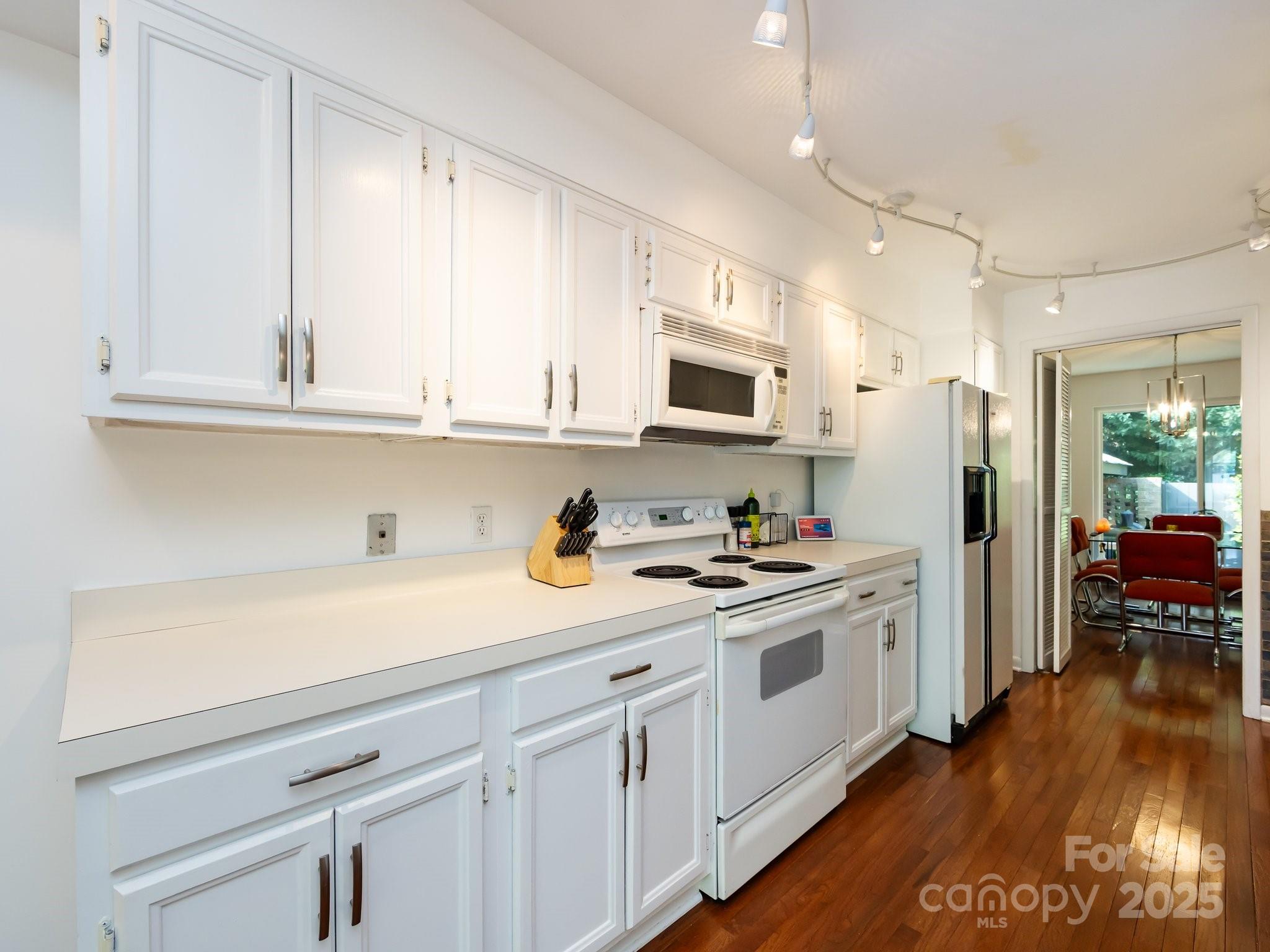 5809 Sharon Road, Unit G Charlotte, NC 28210 - Photo 6 of 25 a kitchen with stainless steel appliances granite countertop a sink a stove a refrigerator and cabinets