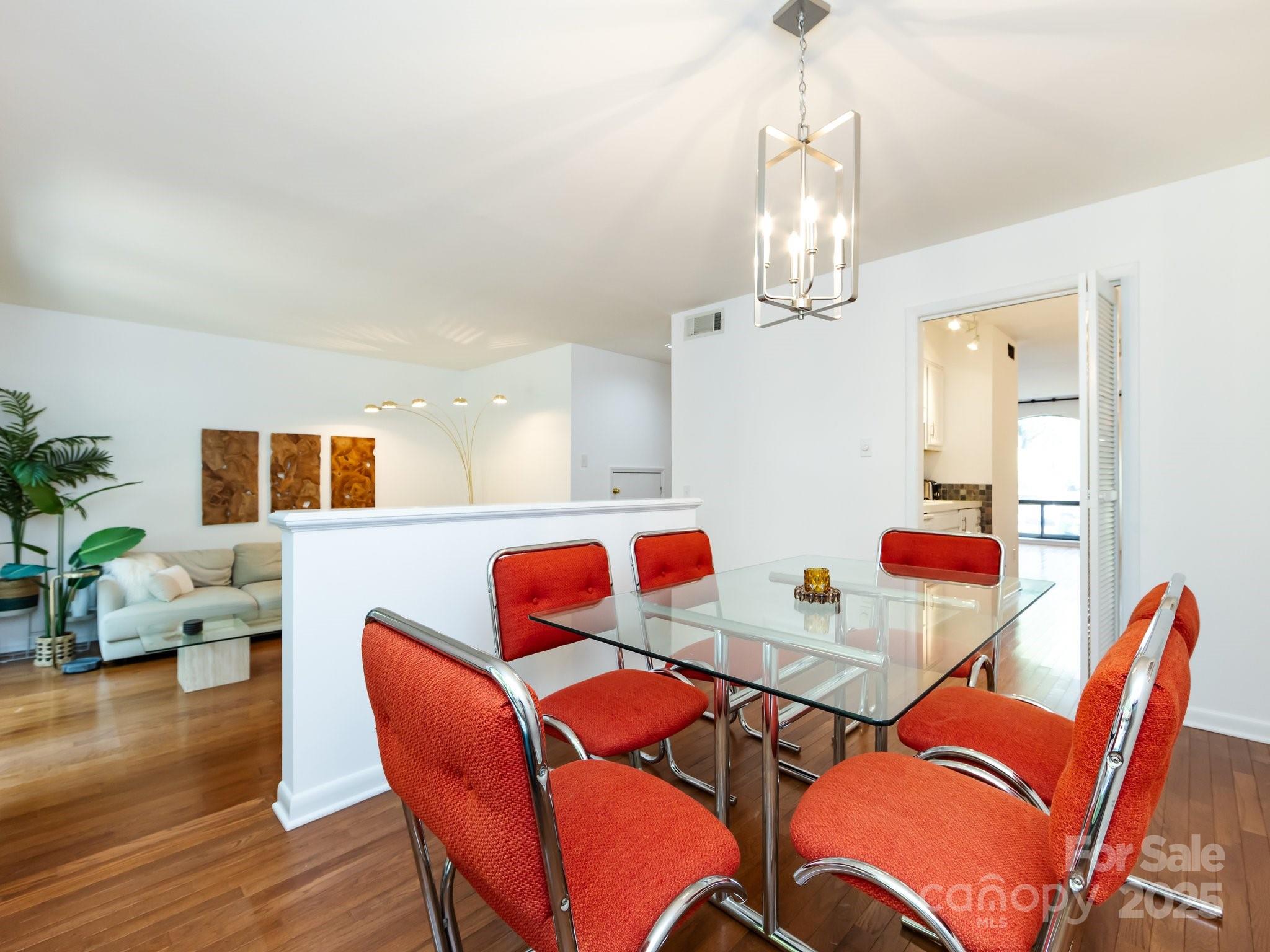 5809 Sharon Road, Unit G Charlotte, NC 28210 - Photo 8 of 25 a view of a dining room with furniture wooden floor and chandelier