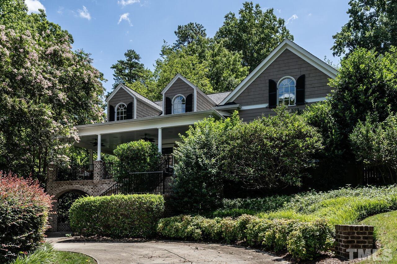 a front view of a house with a yard and potted plants