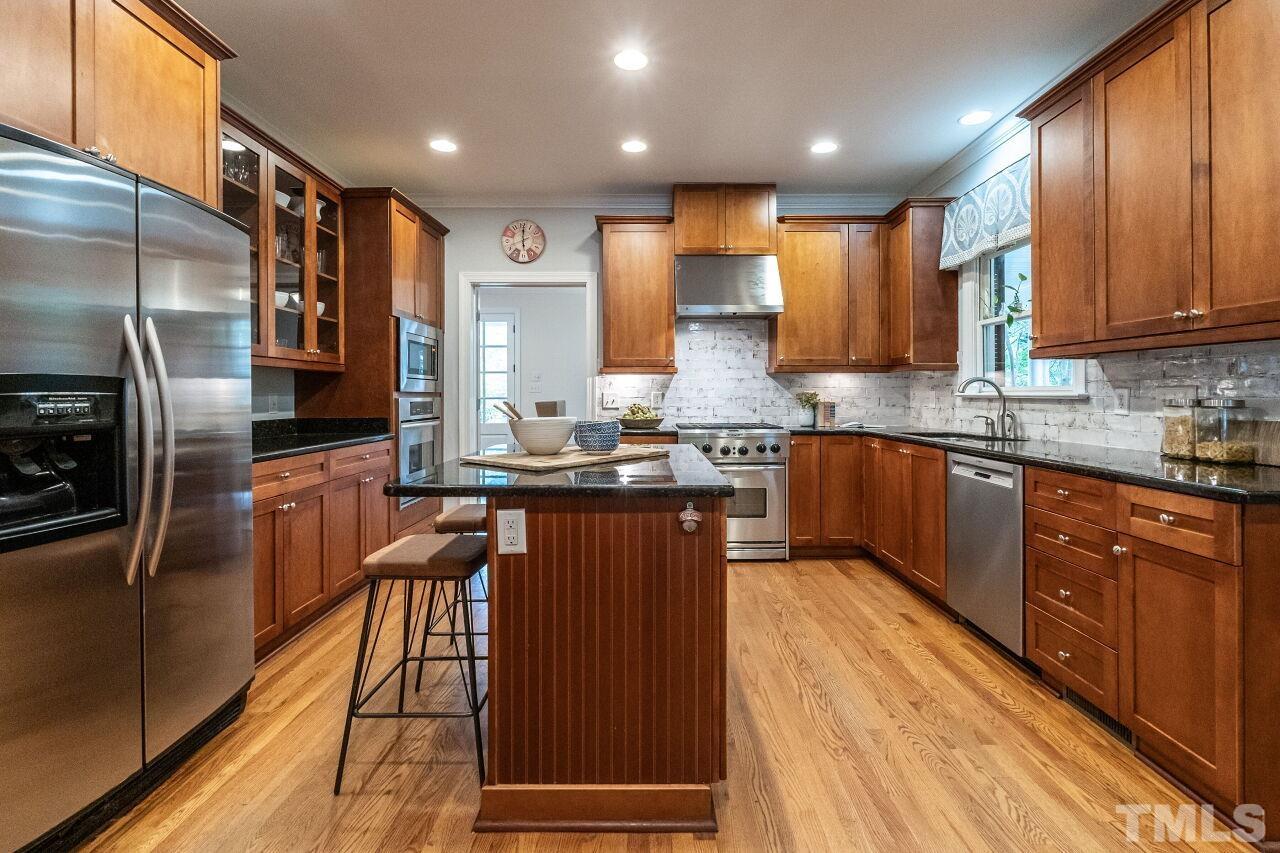 2730 Rothgeb Drive Raleigh, NC 27609 - Photo 15 of 43 a kitchen with stainless steel appliances wooden cabinets a sink and a stove