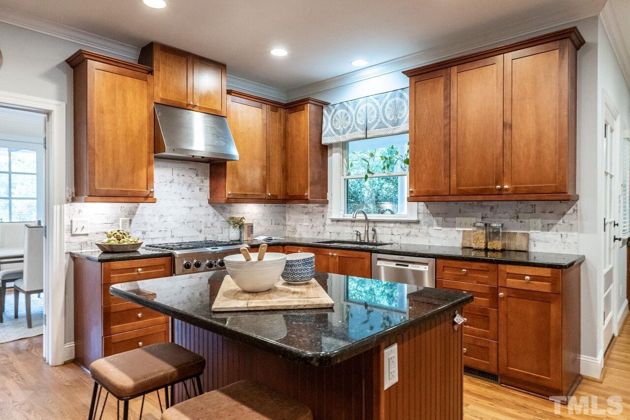2730 Rothgeb Drive Raleigh, NC 27609 - Photo 16 of 43 a kitchen with granite countertop a sink stove and cabinets