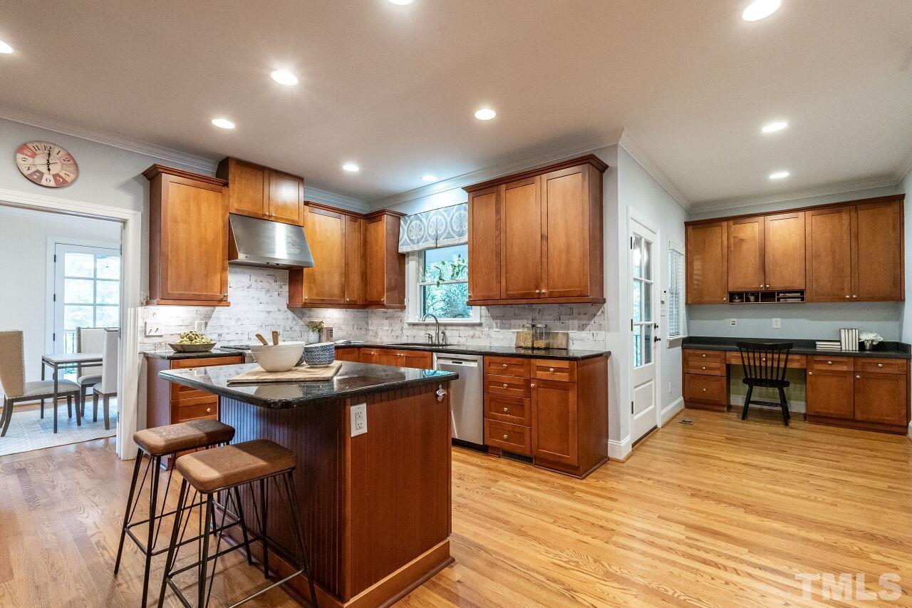 2730 Rothgeb Drive Raleigh, NC 27609 - Photo 18 of 43 a kitchen with stainless steel appliances granite countertop wooden cabinets a stove a sink and a wooden floors