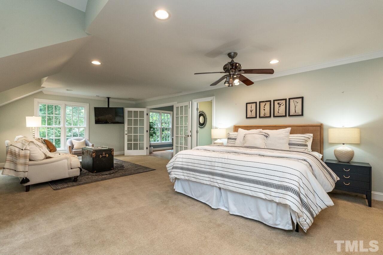 2730 Rothgeb Drive Raleigh, NC 27609 - Photo 27 of 43 a spacious bedroom with a bed a couch and a large window