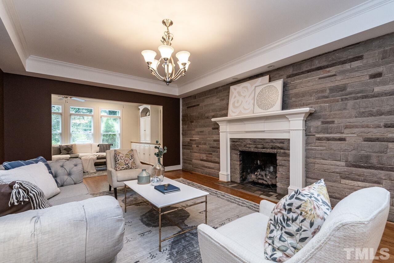 2730 Rothgeb Drive Raleigh, NC 27609 - Photo 9 of 43 a living room with furniture a chandelier and a fireplace