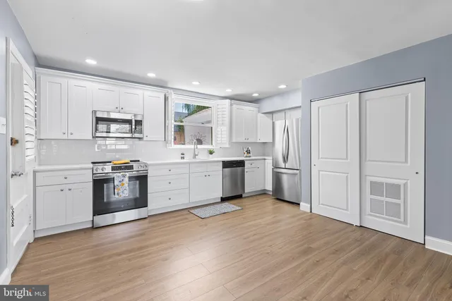 a kitchen with white cabinets and stainless steel appliances
