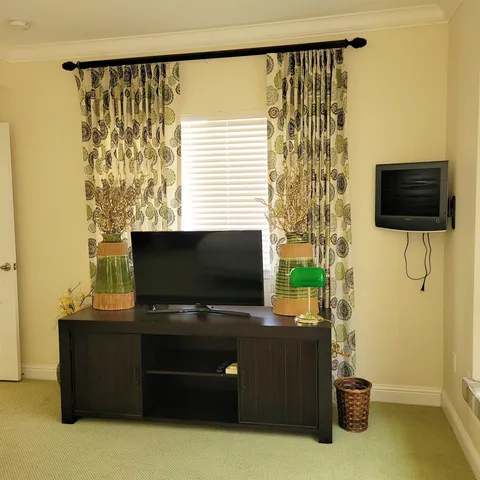 a living room with a flat screen tv and a floor to ceiling window