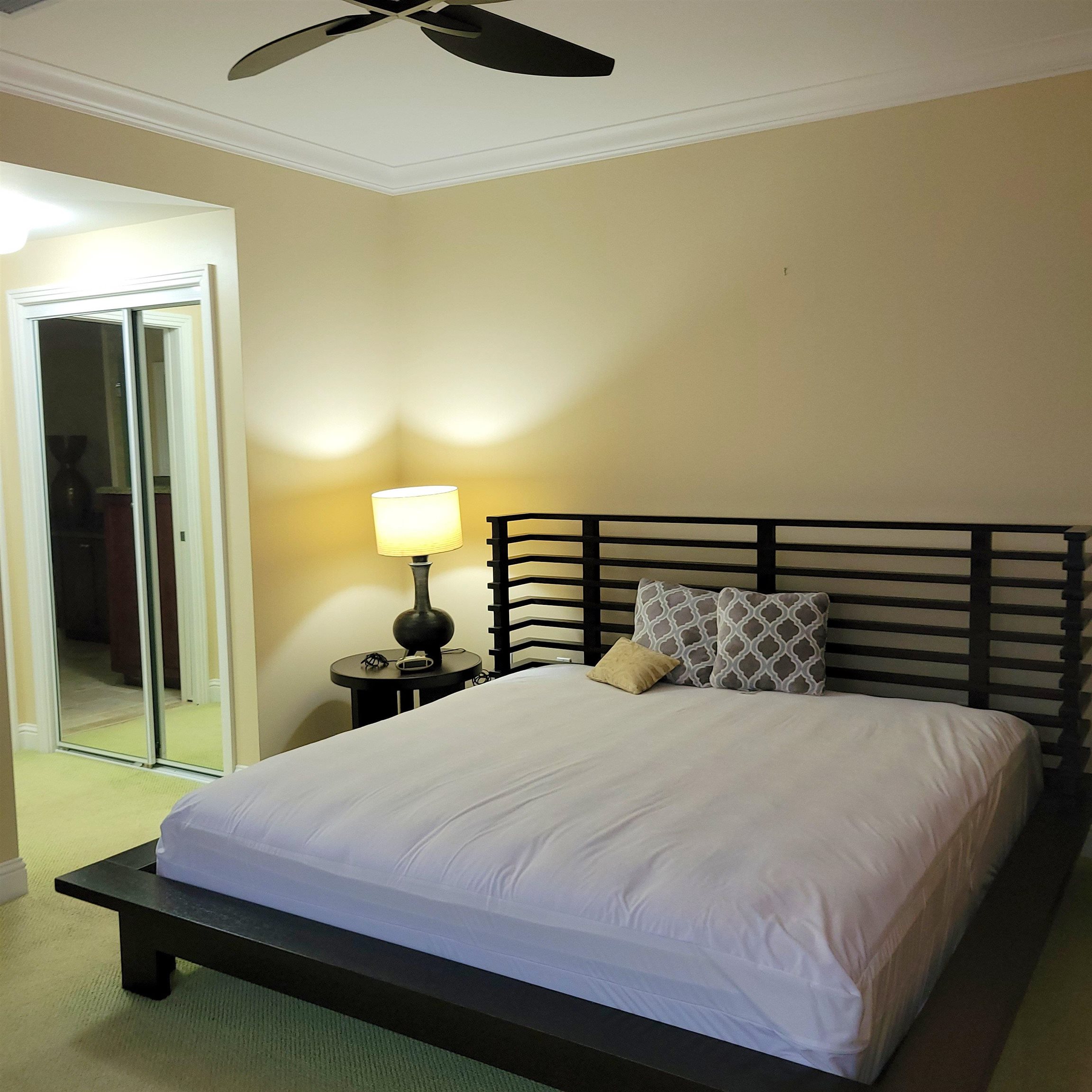 83 Kainehe Place, Unit 9B Kihei, HI 96753 - Photo 14 of 23 a bedroom with a bed and wooden floor