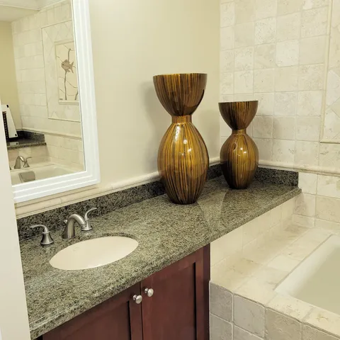a bathroom with a granite countertop sink and a mirror