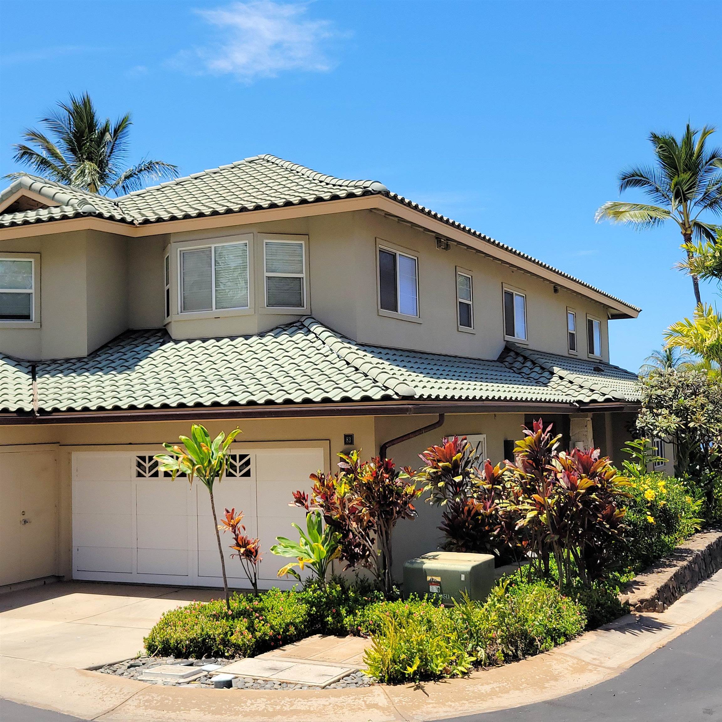 83 Kainehe Place, Unit 9B Kihei, HI 96753 - Photo 2 of 23 a front view of a house with a garden