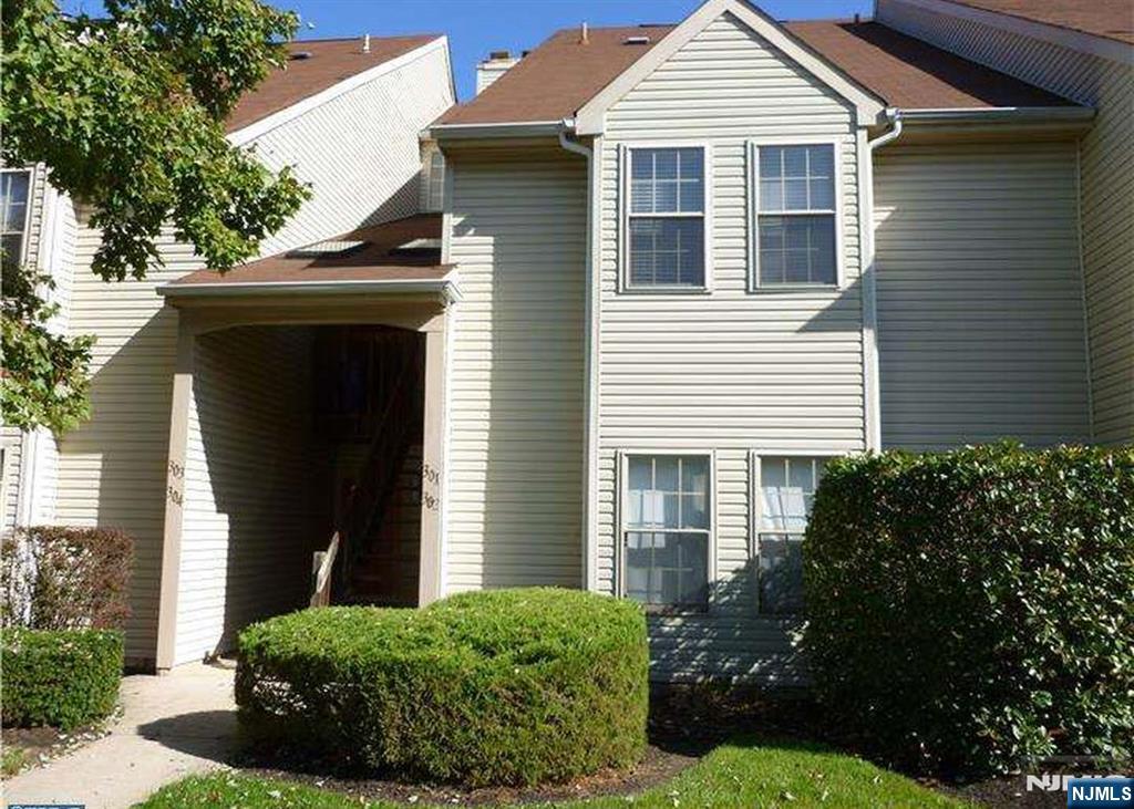 a view of a white house next to a yard