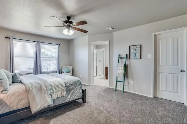 a bedroom with a large bed and a ceiling fan