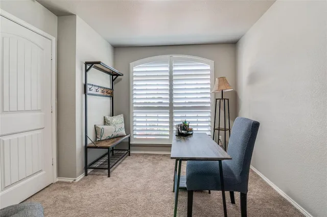 a view of a workspace with furniture and a window