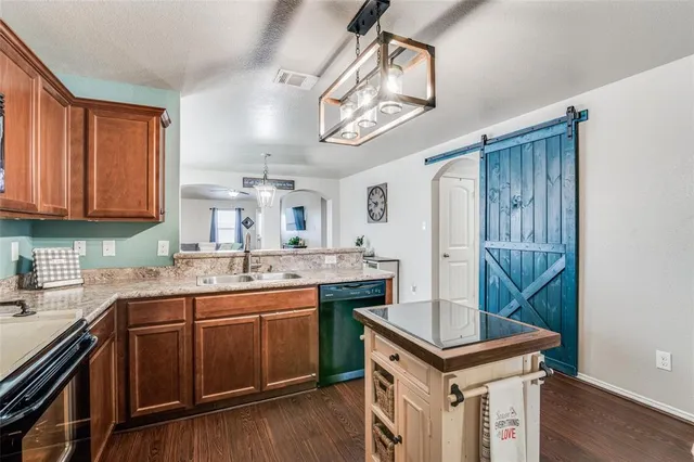 a kitchen with a stove sink and cabinets