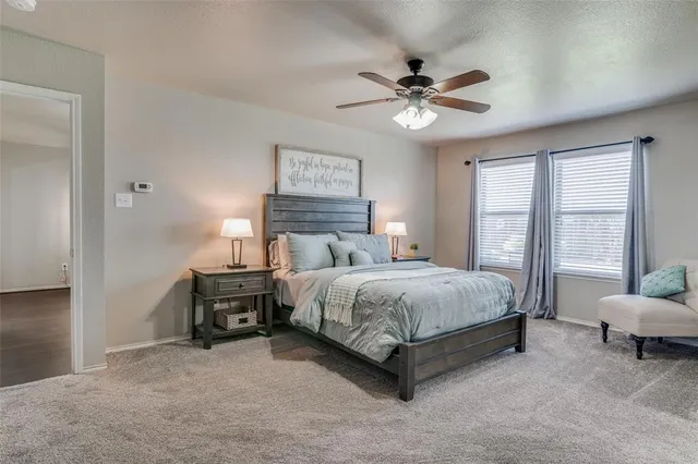 a spacious bedroom with a bed a chandelier and a couch