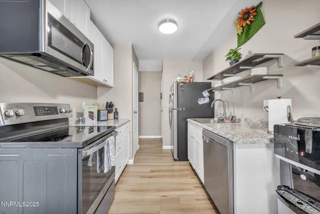 a kitchen with stainless steel appliances granite countertop a stove a sink and a refrigerator