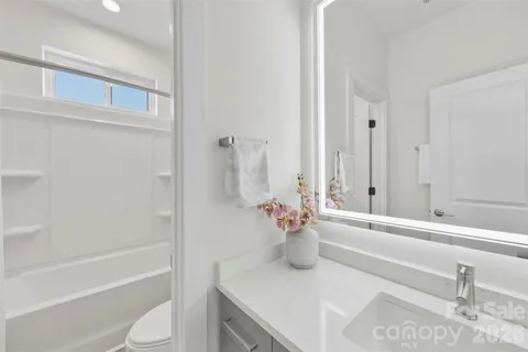 a bathroom with a granite countertop sink and a bathtub