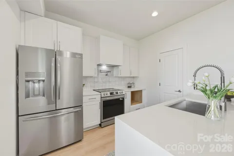 a kitchen with stainless steel appliances a refrigerator sink and stove