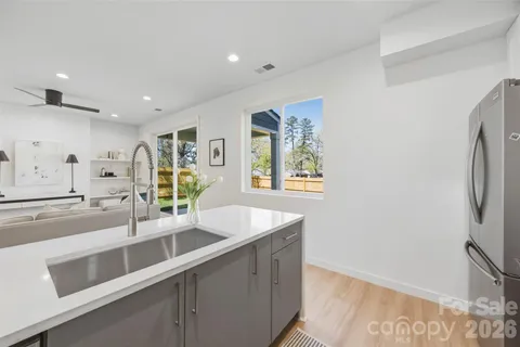 a kitchen with stainless steel appliances granite countertop a sink and a refrigerator