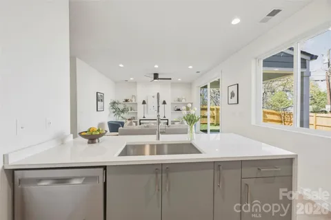 a view of a kitchen with kitchen island a sink wooden floor and a counter top space