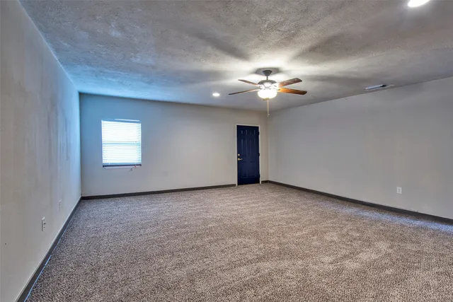 an empty room with a ceiling fan and a window