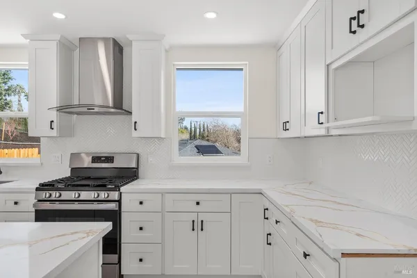 a kitchen with white cabinets and appliances