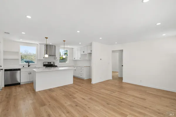 a kitchen with stainless steel appliances granite countertop a refrigerator sink and stove