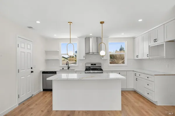 a kitchen with kitchen island a sink stainless steel appliances and cabinets