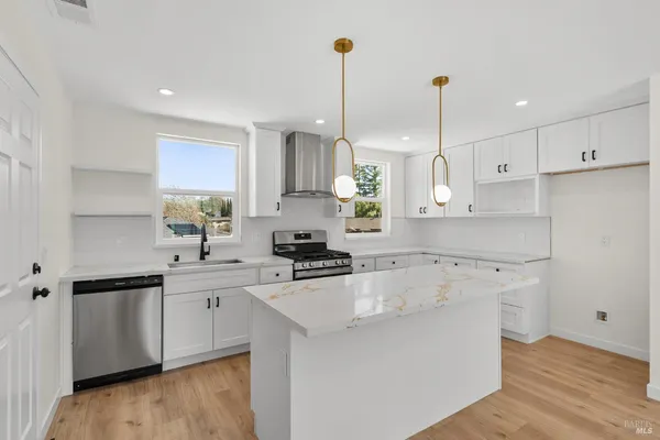 a kitchen with a sink a stove a refrigerator and cabinets