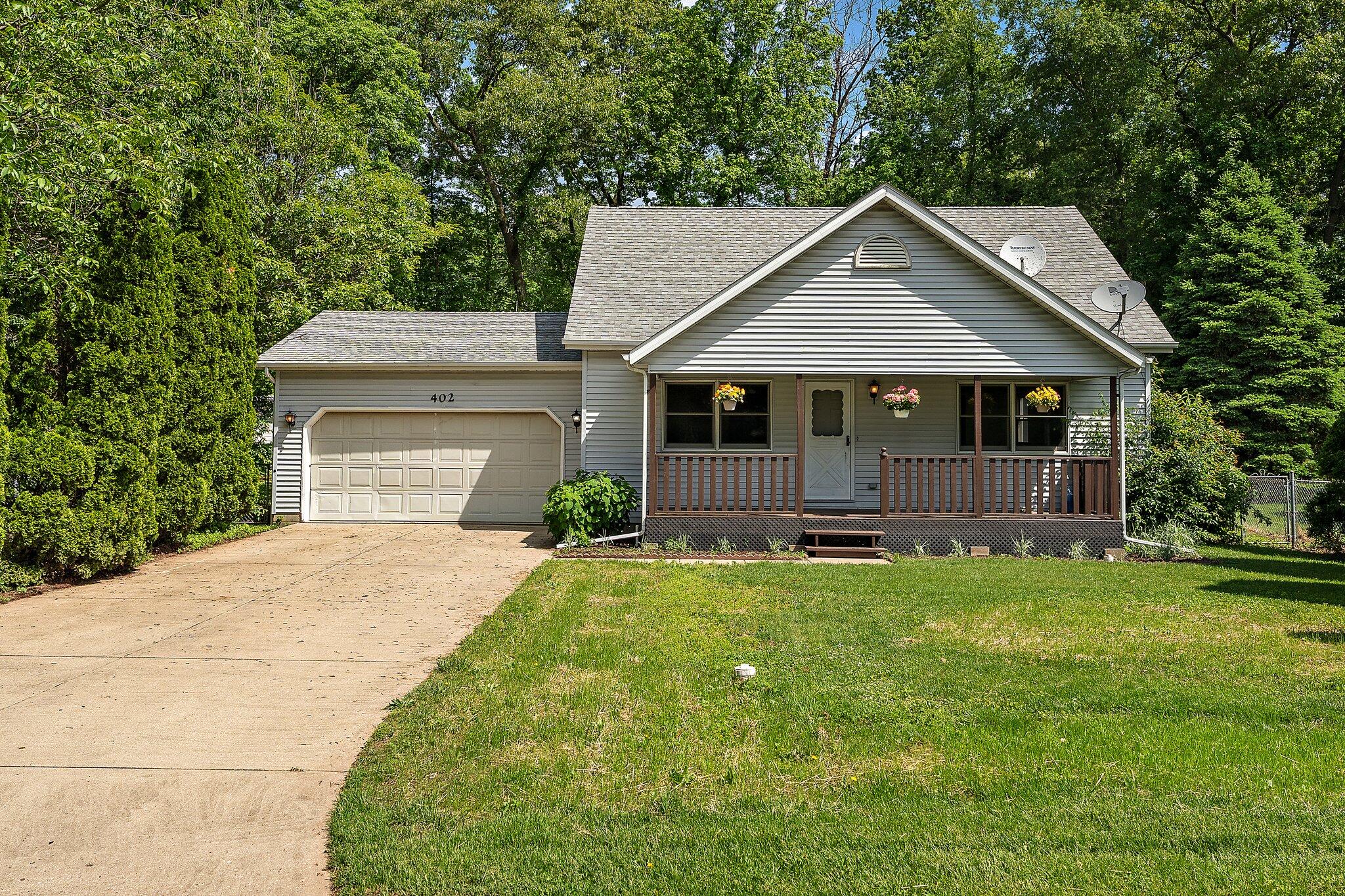 402 Alice Street Kouts, IN 46347 - Photo 3 of 21 a front view of a house with a garden and trees