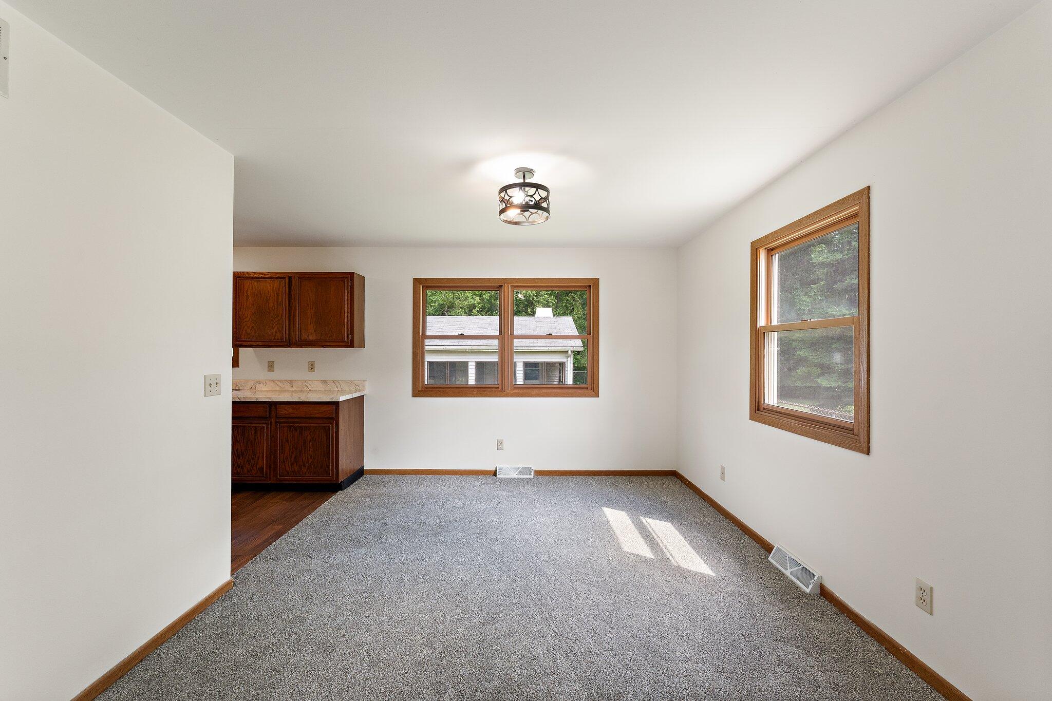 402 Alice Street Kouts, IN 46347 - Photo 7 of 21 a view of an empty room with a window and a kitchen